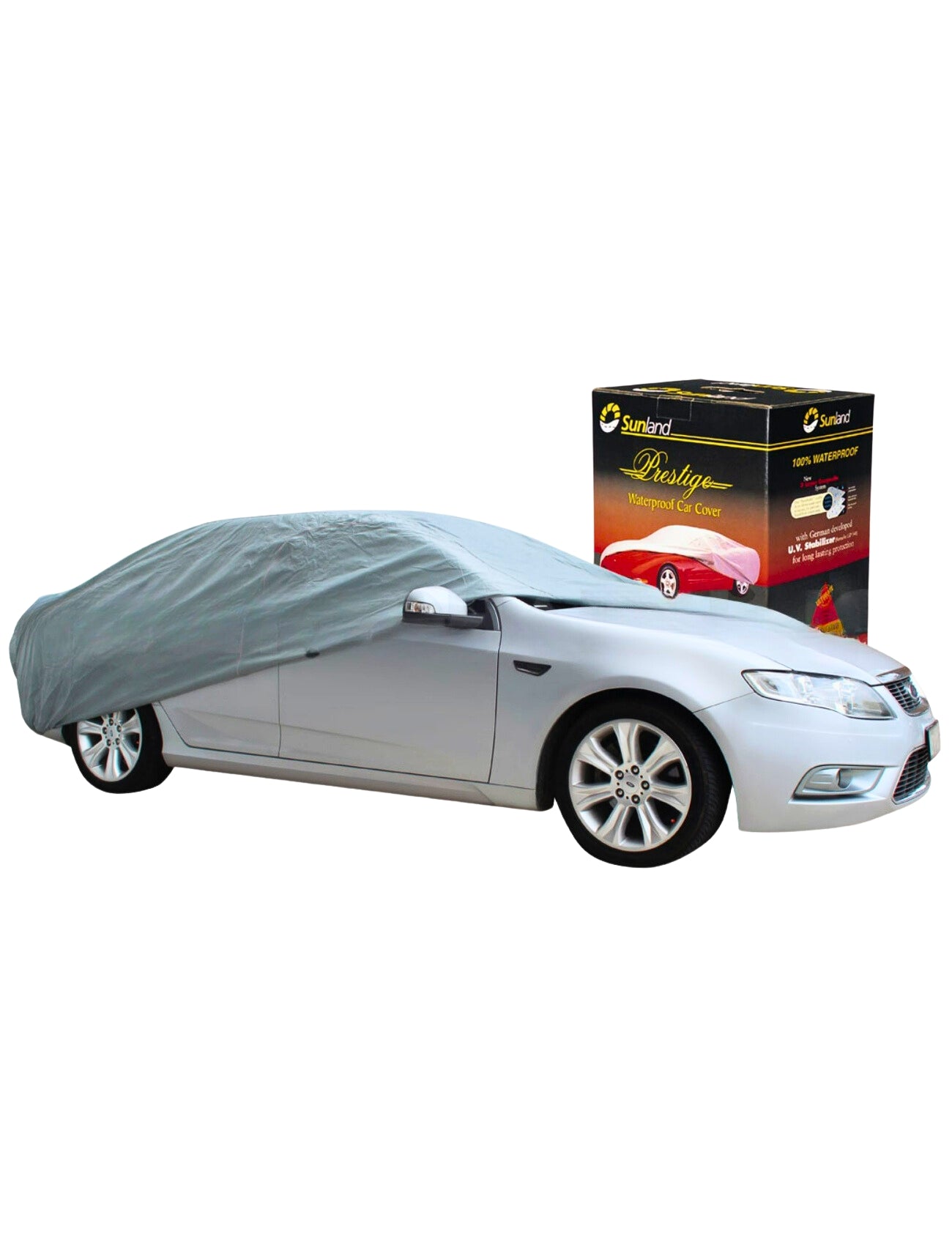 A silver car is partially covered by a Sunland-Protection Car Cover - Small/Medium, famous for being 100% waterproof. The cover elegantly drapes over the vehicle. Behind the car, a product box displays images and text about this UV-stabilized masterpiece.