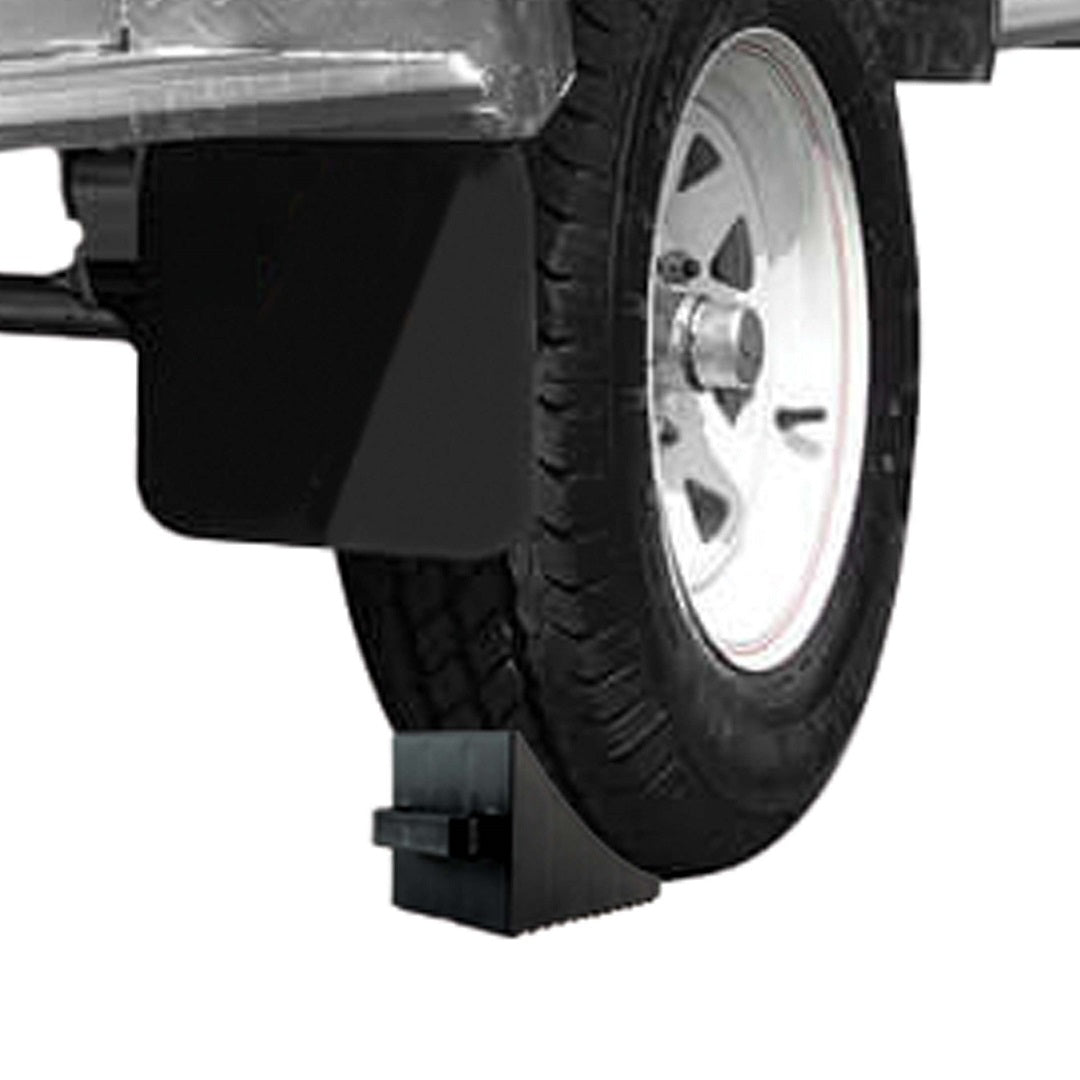 A vehicle's wheel is securely positioned with the Explore Cargo Mate Wheel Chock With Handle underneath it. The ridged tread traction of the chock prevents movement, ensuring the vehicle remains stationary and enhancing overall parking safety.