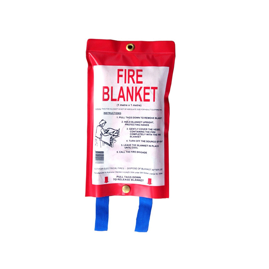 A Drive Fire Blanket - 1m x 1m package, in red, featuring white instructions printed on it. The package includes a gold hanging ring at the top and two blue pull straps at the bottom. An illustration depicts a person deploying the fire blanket over flames, highlighting its use for kitchen safety and fat pan fires.