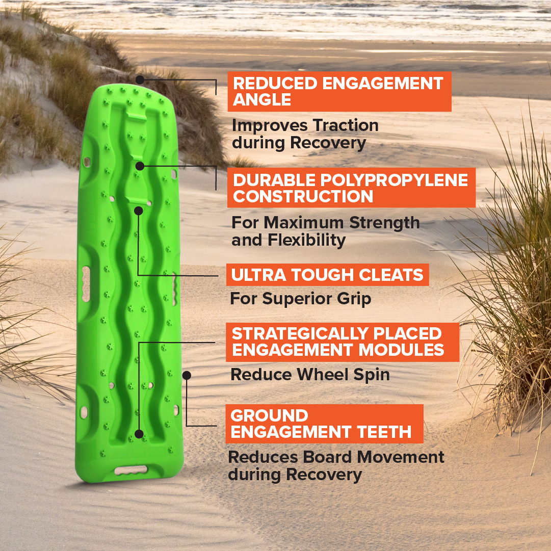 A metallic sunrise red Exitrax Recovery Board 1110 Series stands upright on the sand, featuring reduced traction angle, tough polypropylene, ultra-tough cleats, ground teeth for recovery, modular design, and a lifetime warranty.