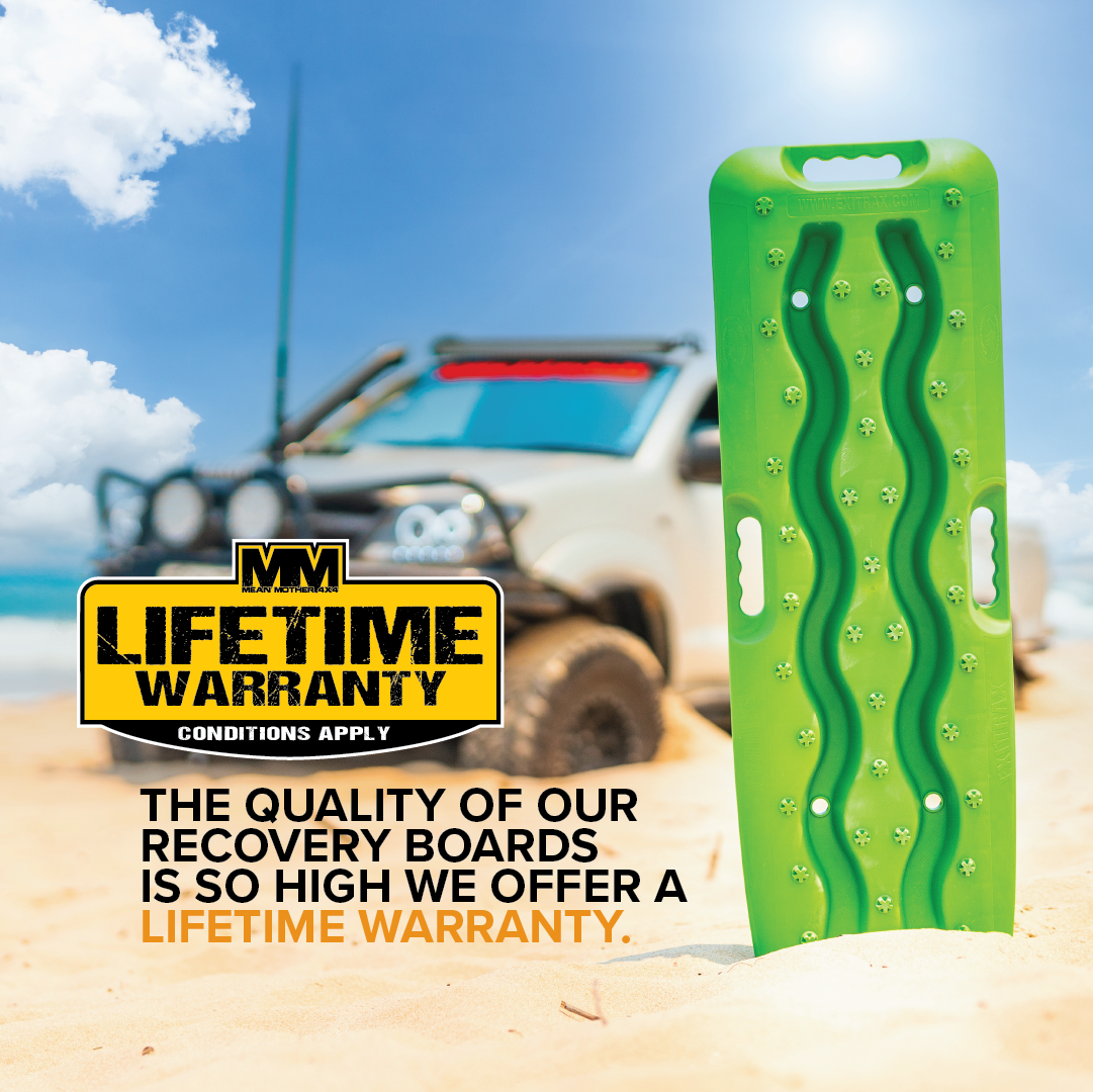 An Exitrax Recovery Boards 930 Series - Green + Mounts Bundle stands upright on sandy ground near an off-road vehicle under a blue sky, with text highlighting its Lifetime Warranty and superior Traction Angle for dependable recovery.