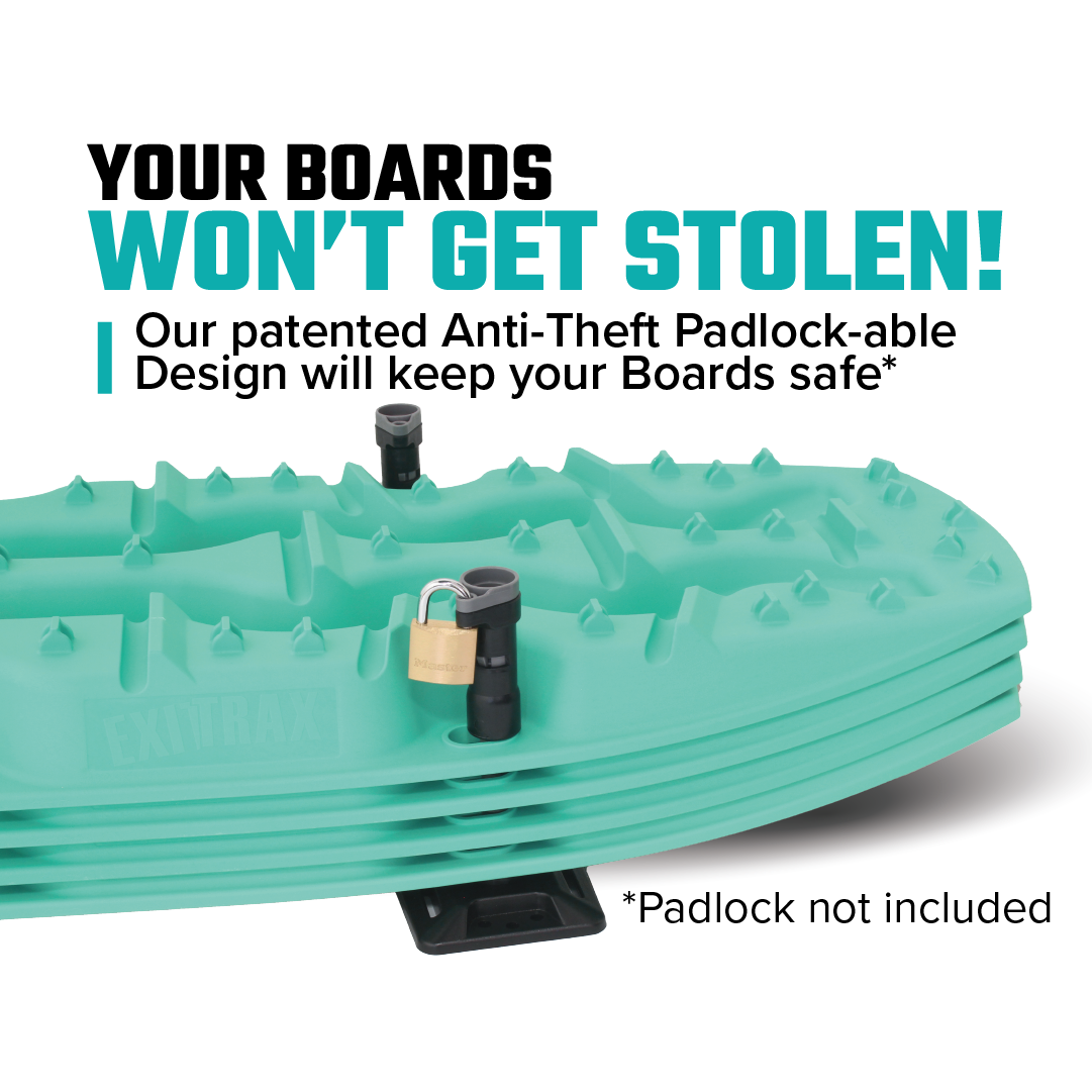 A teal board with a grooved design is shown, featuring two black anti-theft padlock-able mounts from Exitrax. A small padlock is secured to one of the mounts. The text reads: "Your Boards Won't Get Stolen! Our patented Anti-Theft Padlock-able Design with Universal Mounting Brackets from the Exitrax Recovery Board Mounting Kit will keep your Recovery Boards safe.* *Padlock not included.
