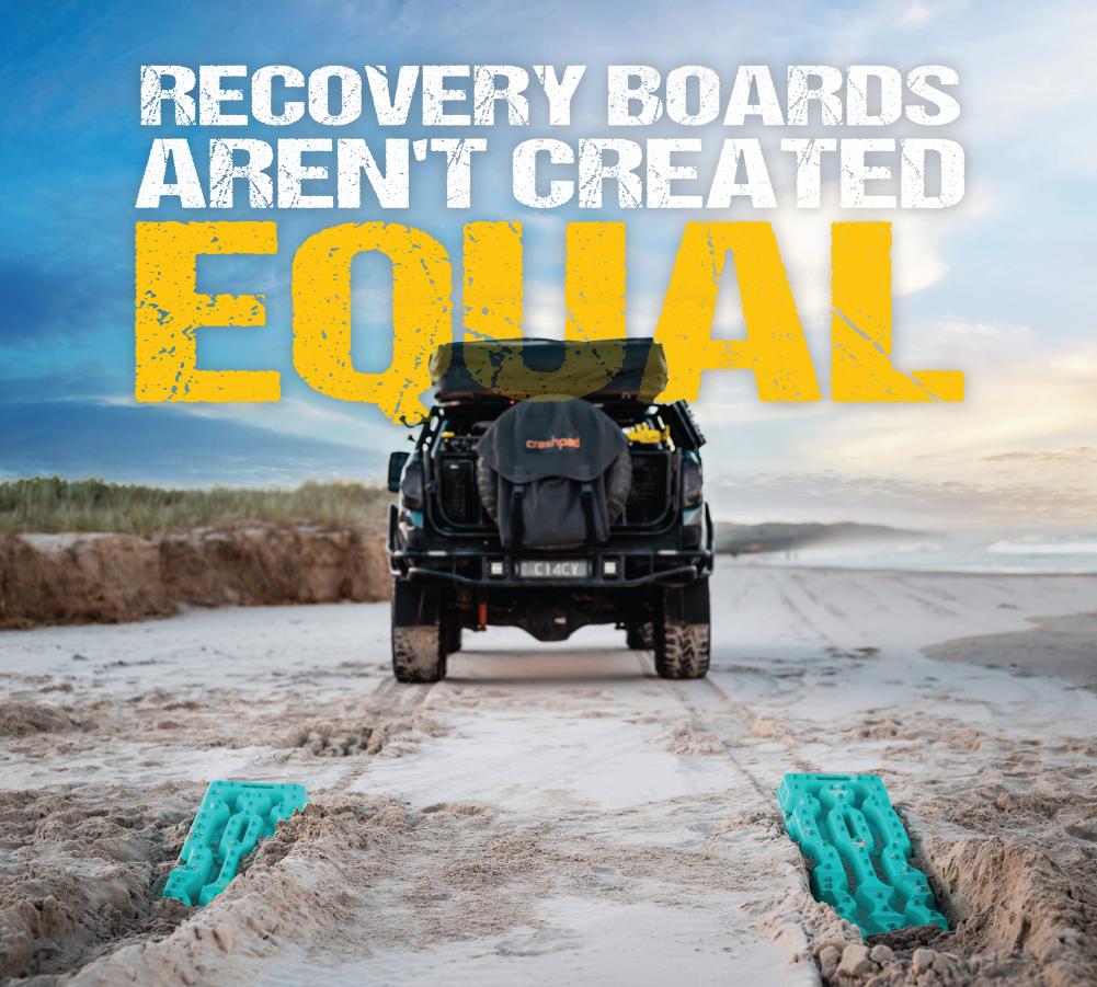 A 4x4 vehicle on a sandy beach is paired with two aqua marine Exitrax Recovery Board Ultimate 1150 in the foreground. The text above states, "Not all recovery boards are created equal." Experience unparalleled traction and peace of mind with a lifetime warranty. The background features a clear sky adorned with clouds at sunset.