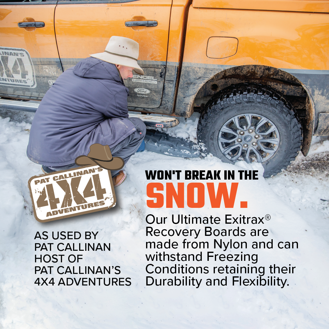 A man in a hat places the Exitrax Recovery Board Ultimate 1150 - Gunmetal Grey + Mounts Bundle under a tire on snow, promoting Pat Callinan's 4x4 Adventures and highlighting their durability and lifetime warranty. An orange vehicle is partially visible.