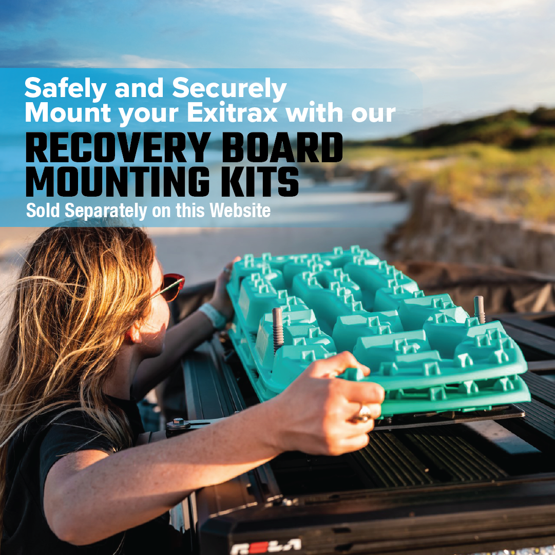 A person with long hair and sunglasses secures an Exitrax Recovery Board Ultimate 1150 - Black on their vehicle's roof using a mounting kit. The sky is sunny, and the terrain is sandy and rugged. Note: Mounting kits available separately online.