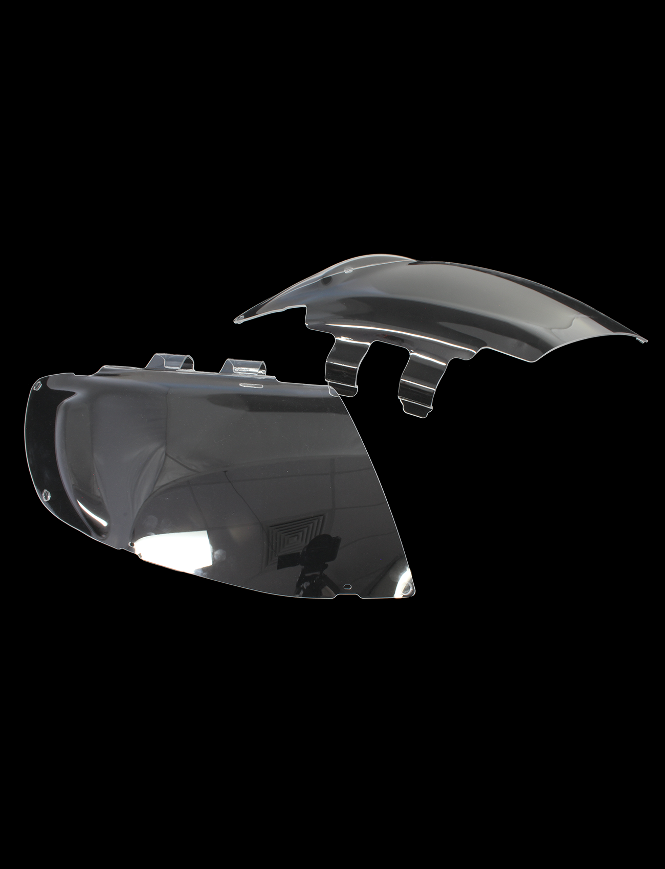 Close-up of two custom-moulded, dark-tinted plastic headlight covers from Sunland Protective Plastics' Mazda BT50 Bundle on a black background. UV-stable with a sleek, curved design and visible mounting fixtures.