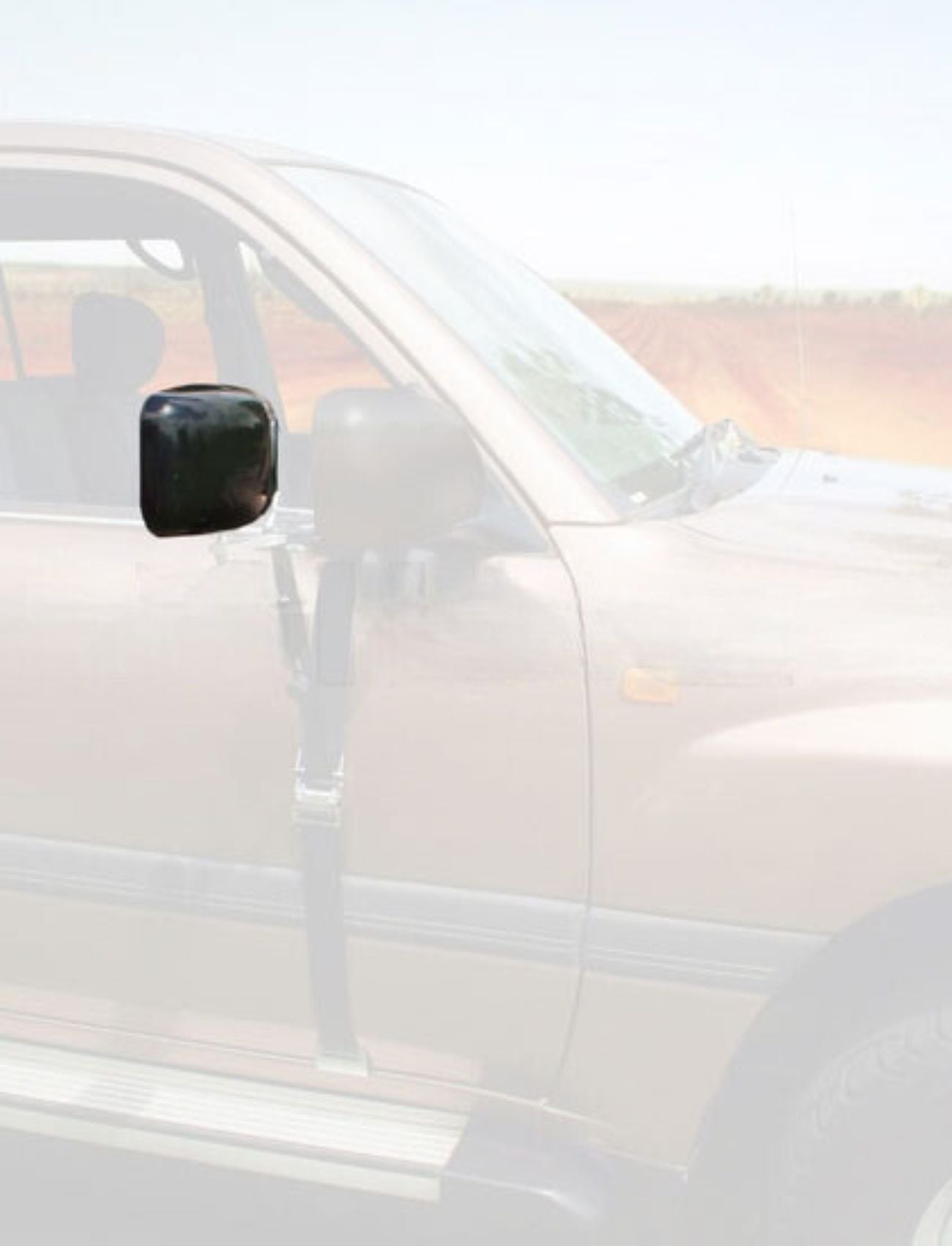 A brown car with a duct-taped side mirror is in a rural setting. On the dirt road, Sunland-Protection's MIRROR HEAD -SUITS MH3015 could be the perfect replacement for its journey toward the distant horizon.