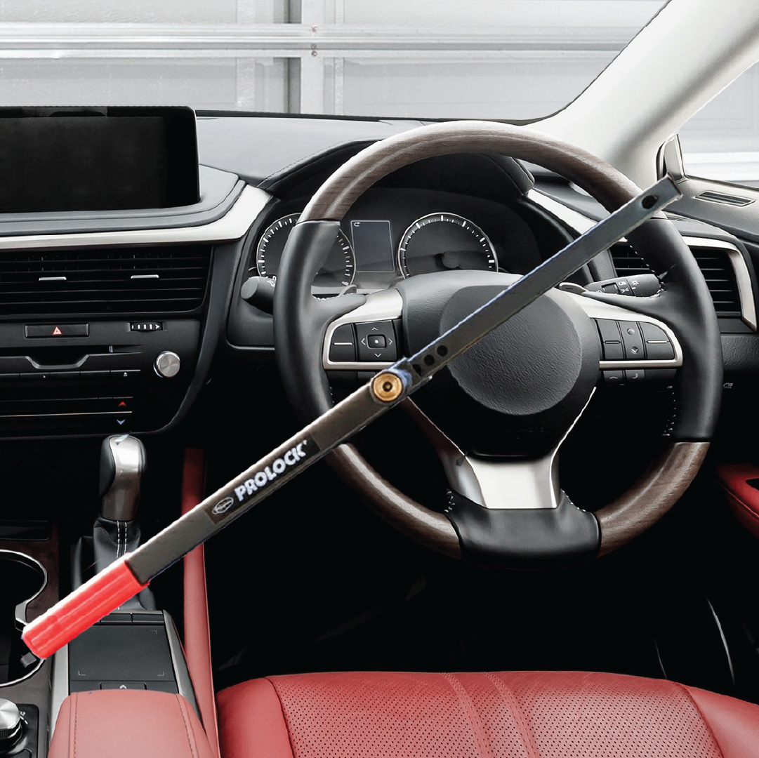 A Sperling Steering Wheel Lock Prolock with a red handle secures the car’s steering wheel in a modern vehicle with a red and black interior, providing enhanced security.