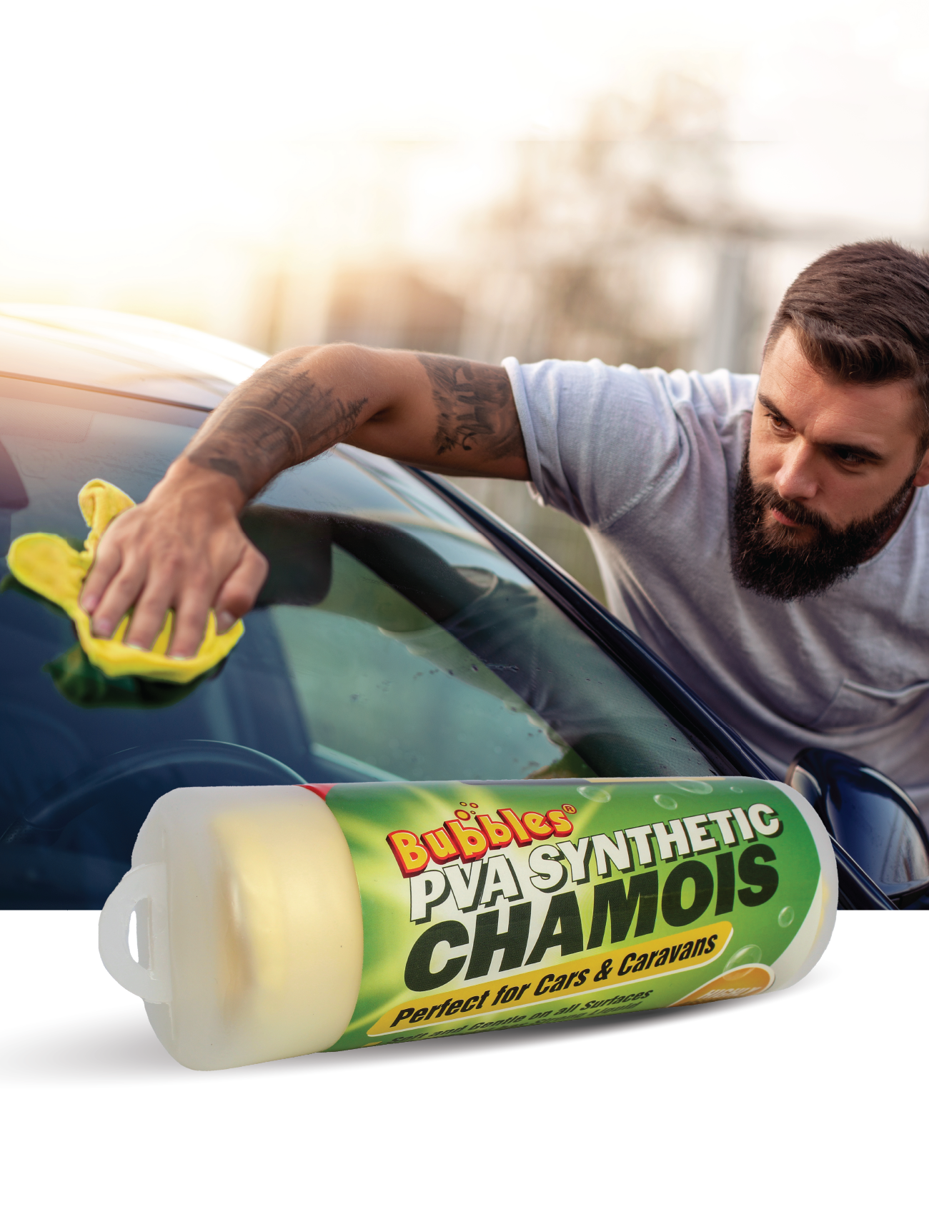 A bearded man uses a yellow Sunland-Protection CHAMOIS SYNTHETIC PVA 43 x 32cm to clean a car's windshield, achieving a streak-free finish. The packaging is clearly visible in the foreground.