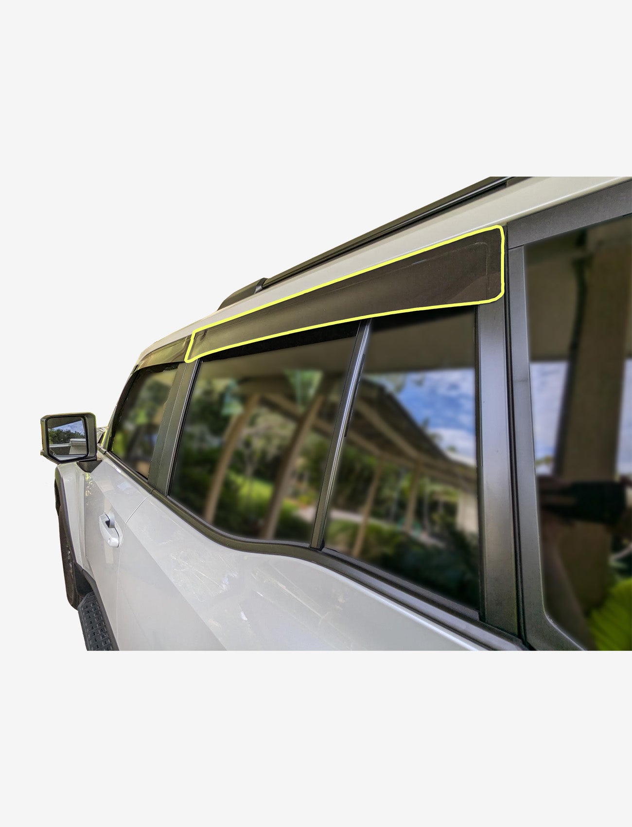 Side view of a white SUV with Sunland Protective Plastics Toyota Prado 250 Series Slimline Rear Passenger Weathershield in dark tint, made from UV stable acrylic, installed above the tinted windows and reflecting greenery and a covered walkway.