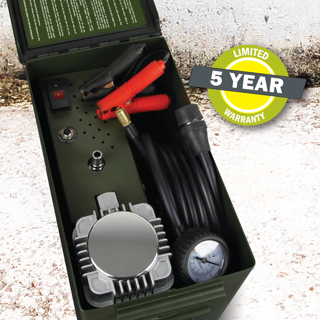 A sturdy green metal box, designed like a robust ammunition case, houses the Dr Air Ammo Box Air Compressor | 4WD Air Compressor 150 Lpm. It includes a tire inflator with an attached pressure gauge, red and black cables, and an on/off switch. The military-tough design features a textured background with a "Limited 5 Year Warranty" sticker.
