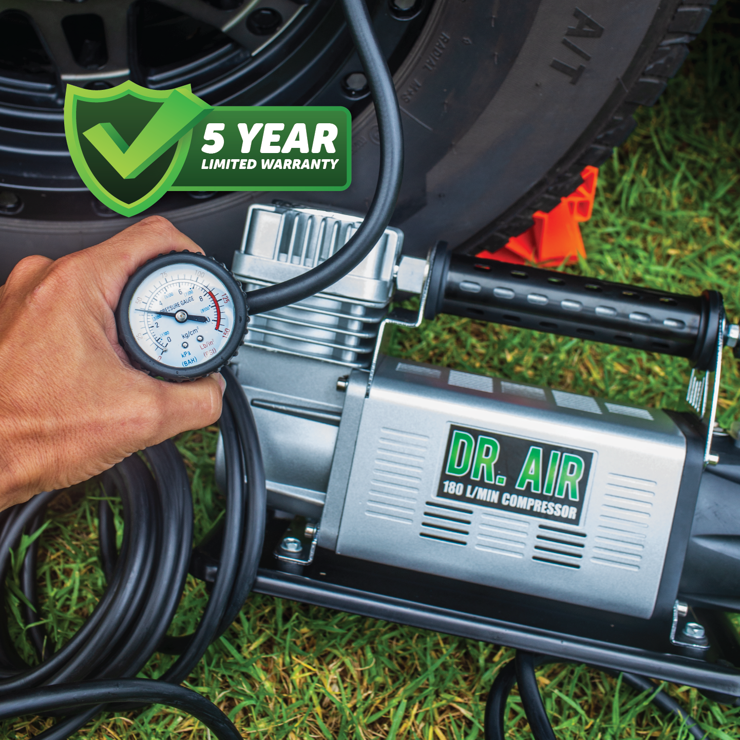 A person is using a Dr Air 12V Air Compressor 180Lpm with a pressure gauge to inflate a tire. The image prominently features a green shield displaying the text "5 Year Limited Warranty," providing assurance of reliable air delivery for your peace of mind.