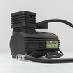 A Dr Air 12V Air Compressor 250psi, featuring a pressure gauge, a flexible hose, and adorned with a green label on its black body, is set against a plain white background.