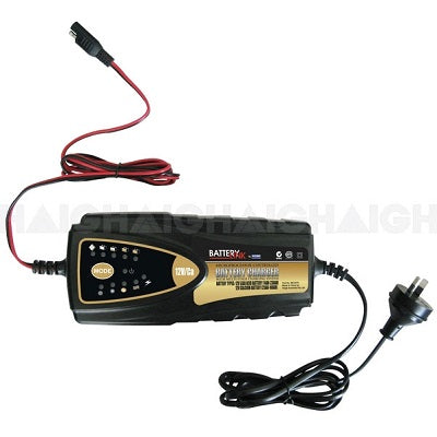 The image depicts the Battery Link 7Amp Smart Battery Charger, a 12V device designed in black and yellow. It features cables with connectors on both ends—one for connecting to deep cycle batteries, and the other with a standard power plug for electrical outlets. This charger incorporates advanced microprocessor technology and has an LED display on the front.