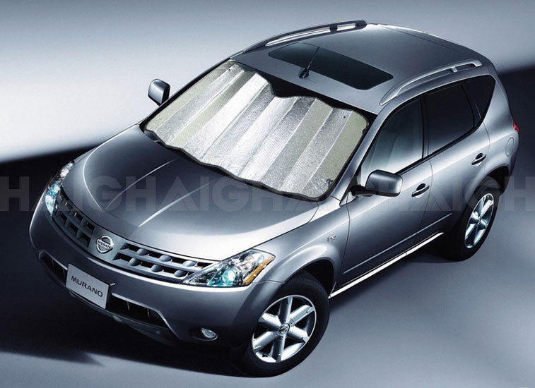 A silver SUV with Sunland-Protection’s Car Sun Shade (150cm x 85cm Silver) is parked on a smooth surface. The air bubble insulated shades provide excellent UV protection and reflect light, enhancing the vehicle's sleek look alongside its tinted windows. The scene is indoors or under controlled lighting.
