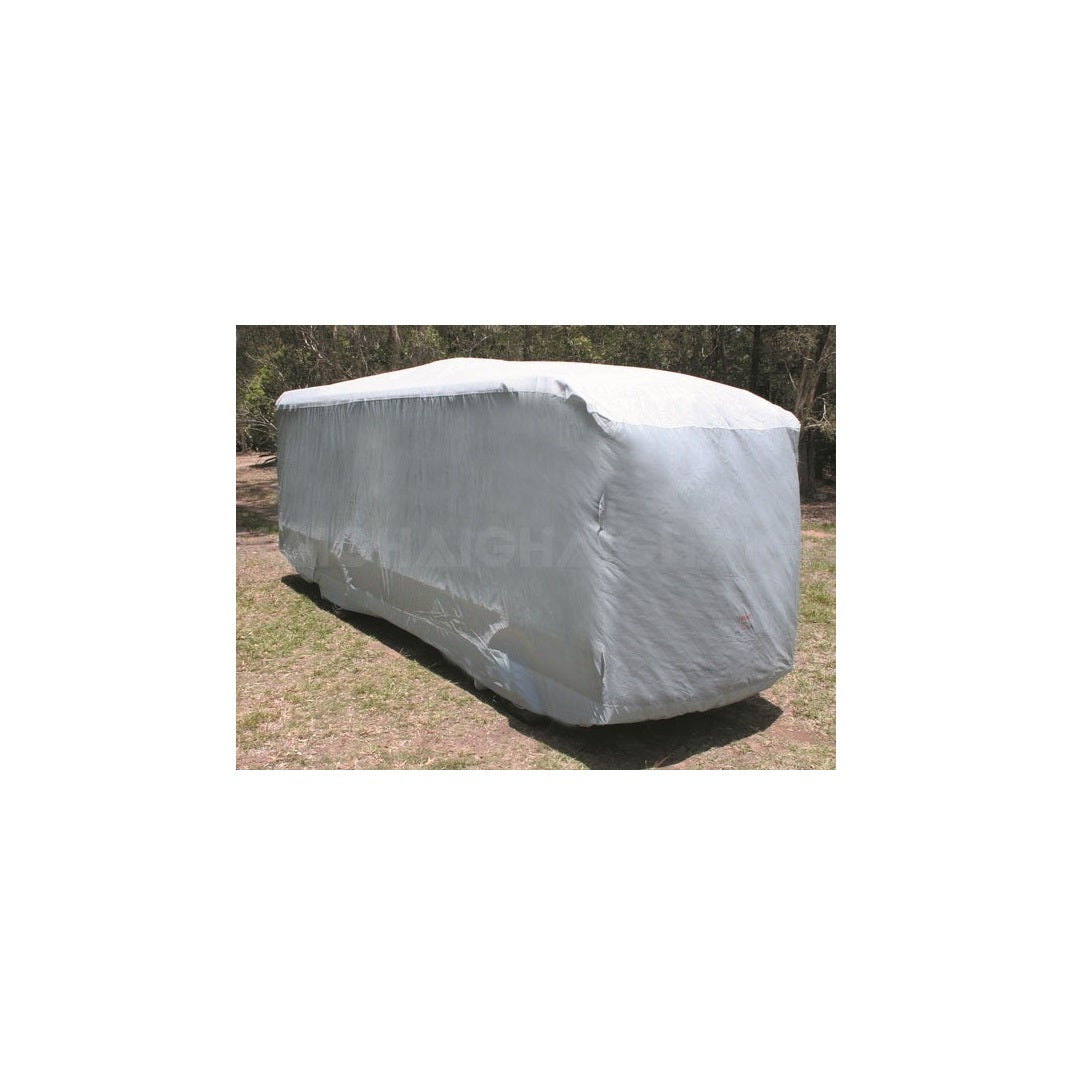 A Prestige Class A Motorhome Cover in light gray, sized 10m-11.5m, made from UV-stabilized, waterproof fabric, shelters an RV parked on grass with trees in the background under a clear sky.