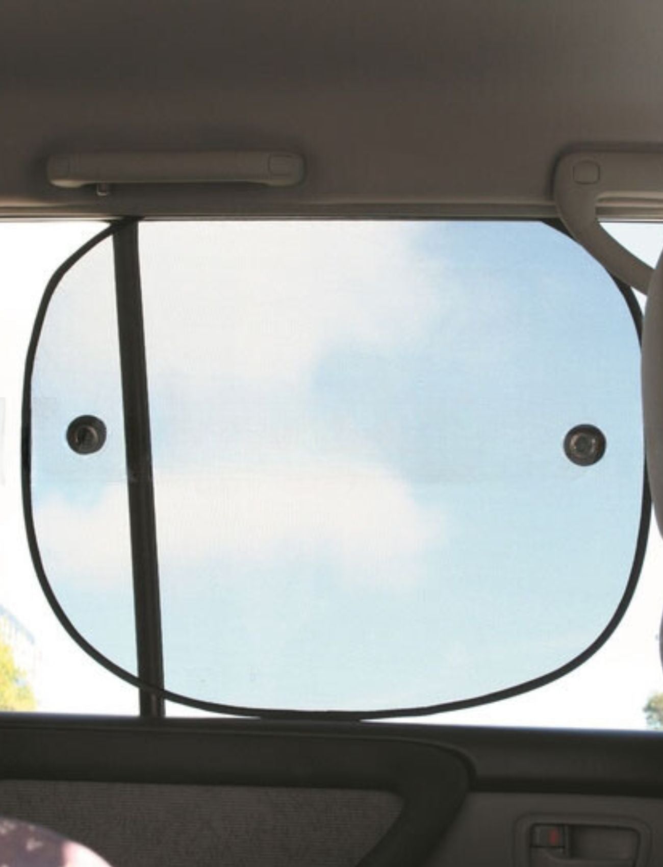 View from inside a car with the Sunland-Protection Car Sun Shade attached to the side window using two suction cups. The black frame contrasts with the blue sky and scattered clouds visible through the shade.