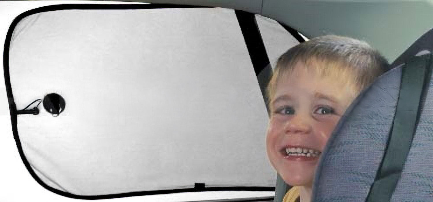 A child with short hair smiles in the back seat of a car, where Sunland-Protection's Car Sun Shade is attached to the window. These Interior Side Window shades are easy to use and partially visible behind the child, while the textured fabric of the car seat ensures a comfortable journey.