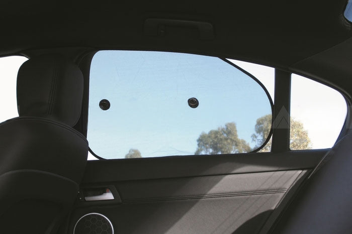 A backseat view highlights the Sunland-Protection Car Sun Shade for interior side windows, easily attached with two suction cups. It partially covers the window, framing a spring scene of trees and a clear blue sky.