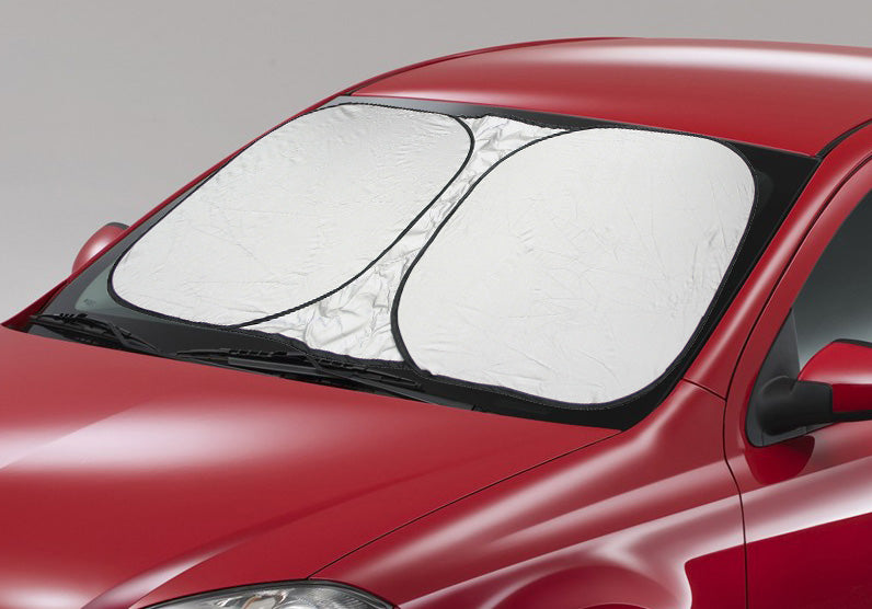 A red car parked on a gray background is equipped with the Interior Reflex Sun Shade from Sunland-Protection, measuring 72cm x 146cm. This silver sunshade not only displays elegant white circular patterns but also provides interior protection to keep the car environment cooler.