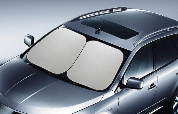 A vehicle in a gray finish is equipped with the Sunland-Protection Interior Reflex Sun Shade Silver, measuring 85cm x 75cm x 2. This sunshade effectively covers the entire front windscreen, blocking sunlight from entering the interior. From an aerial perspective, the car highlights its sleek design and features a sunroof.