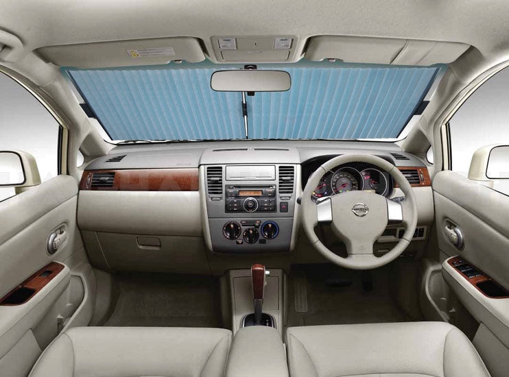 The car's interior features a beige dashboard with air vents and controls, complemented by the Sunland-Protection Car Sun Shade Interior Accordion 62cm with UV defense on the windshield. Beige and wood accents adorn the dashboard, while cream leather seats are visible in the foreground.