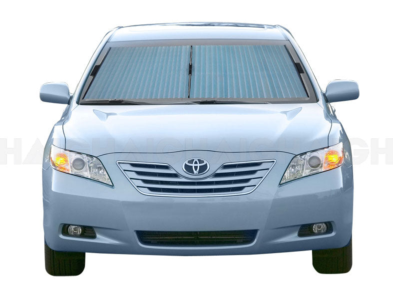 A light blue sedan features a Sunland-Protection Car Sun Shade Interior Accordion (62cm) covering the front windshield. The headlights are on, and its sleek design and UV protection stand out against the plain white background, while the Toyota logo is visible on the grille.