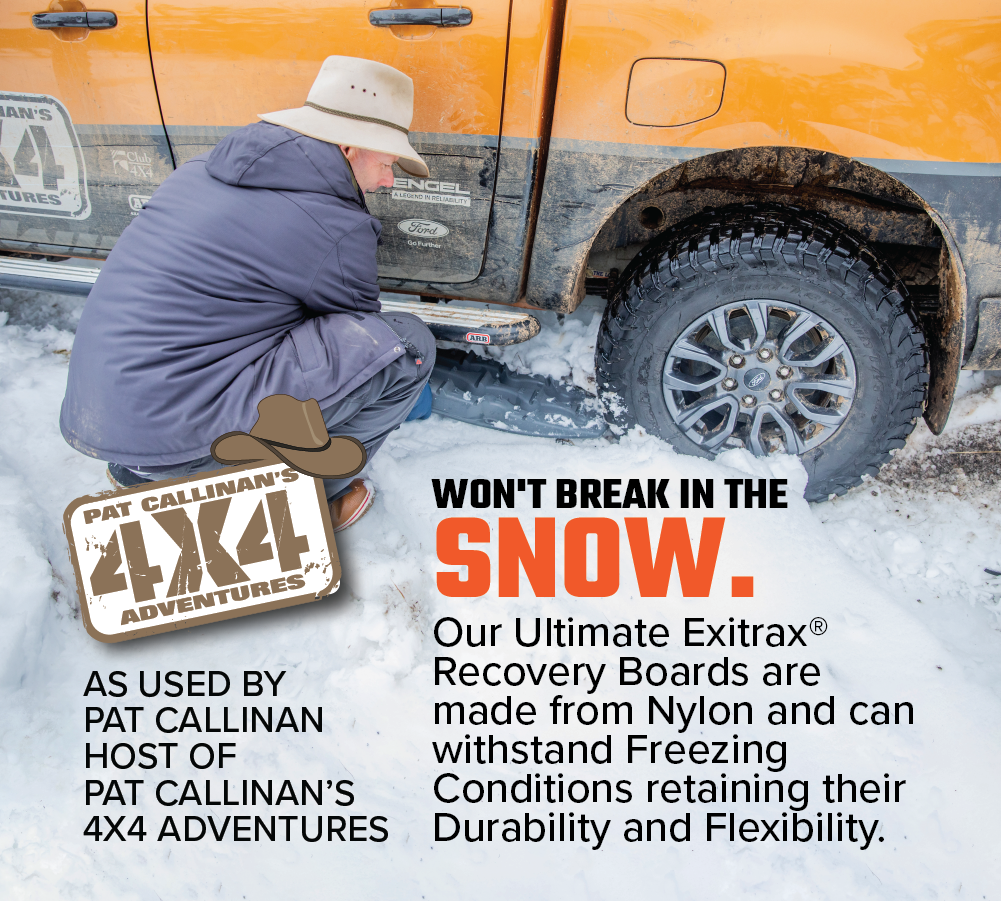 On a snowy ground, a person is kneeling next to an orange truck, placing an Exitrax Recovery Board Ultimate 1150 in Aqua Marine under the tire. The board emphasizes its durability in freezing conditions. A logo referencing Pat Callinan's 4x4 Adventures highlights its compatibility with the Recovery Board Mounting Kit included in the bundle.