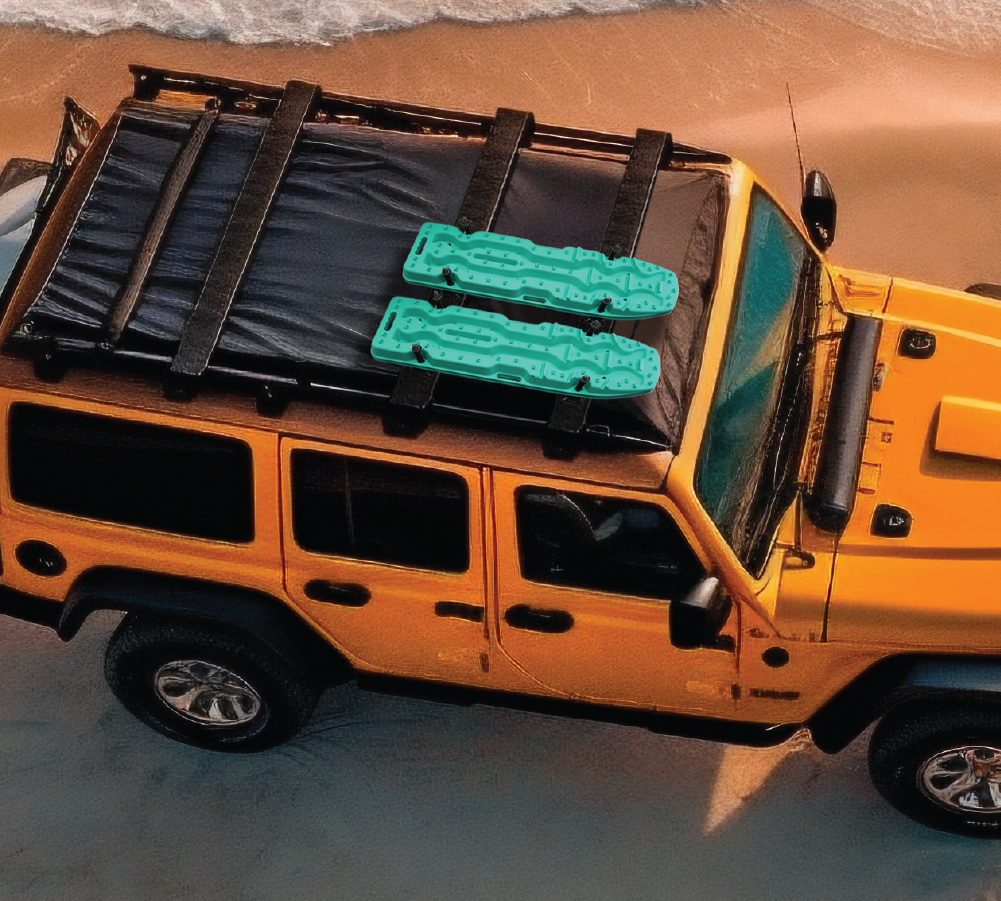 A vibrant yellow Jeep is parked on a beach with ocean waves nearby. Equipped with a black cargo rack holding two Exitrax Recovery Board Ultimate 1150 in Aqua Marine from Exitrax, the Jeep embodies an adventurous coastal setting, ready for any 4x4 excursions.