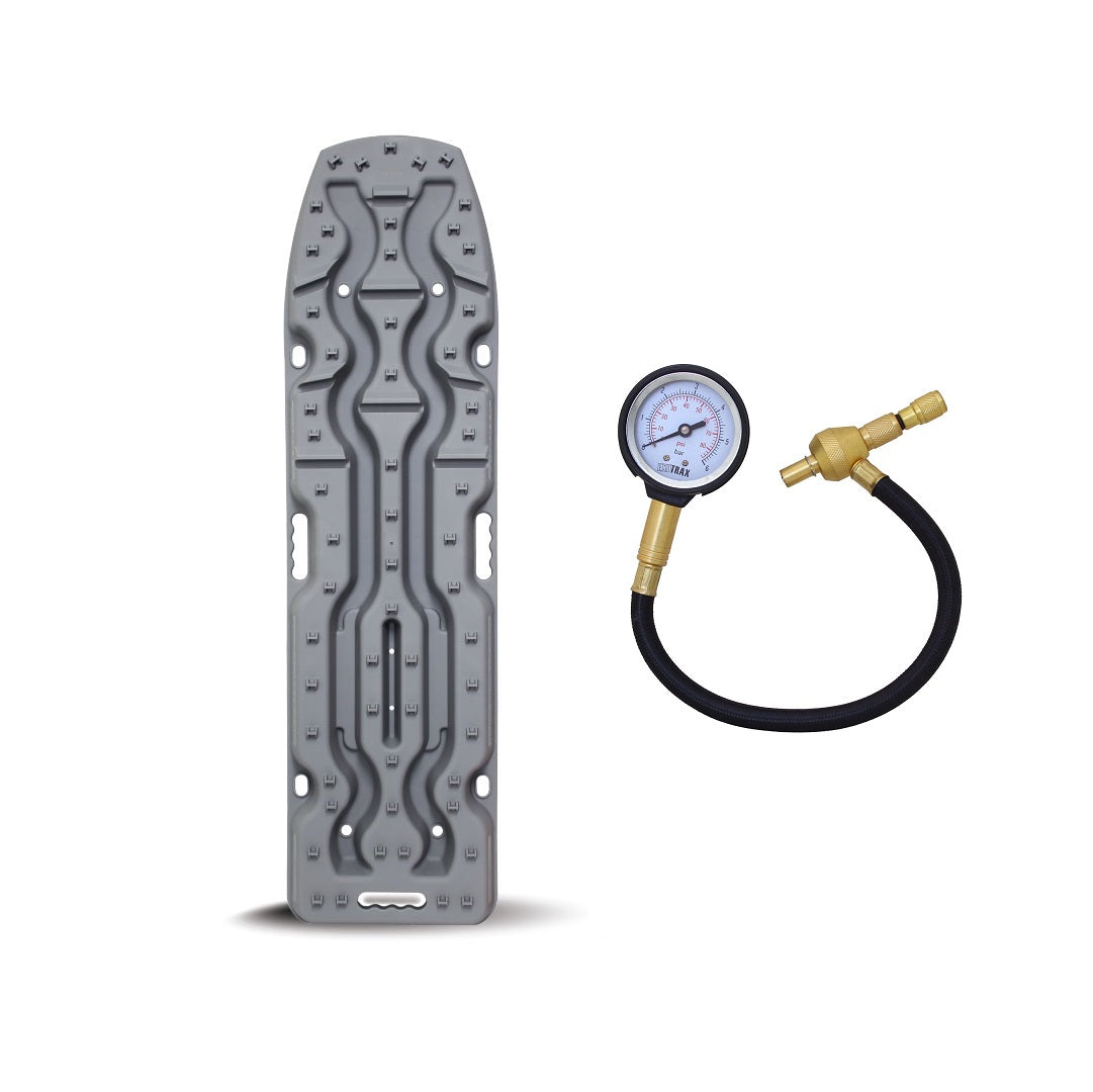 A gunmetal grey tire repair kit featuring a contoured metallic tool and an Exitrax Tyre Deflator with a black rubber hose and brass valve attachment, from the Exitrax Recovery Board Ultimate 1150 set.