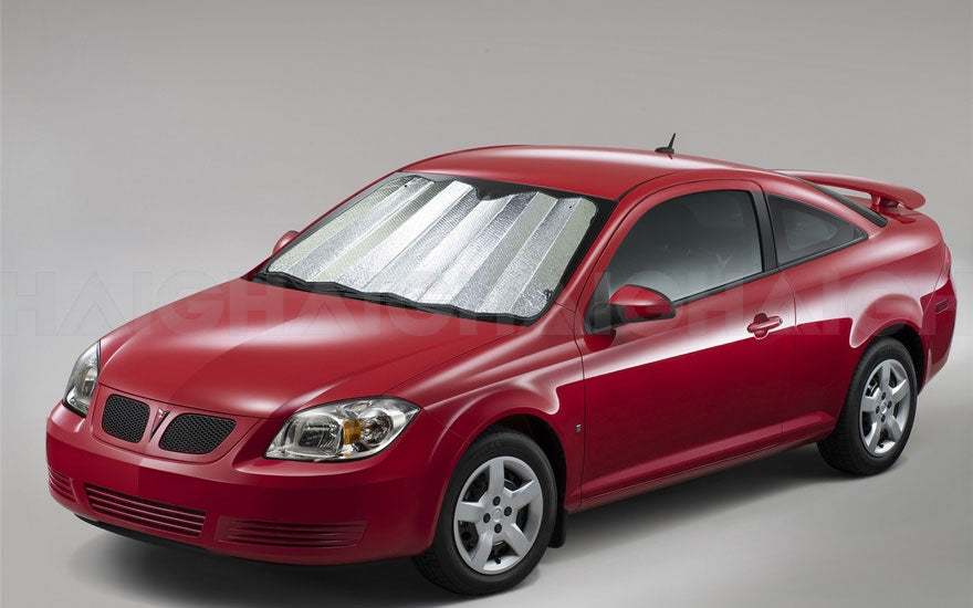 A red coupe showcases the Sunland-Protection Car Sun Shade 150cm x 70cm Silver for UV protection against a plain gray background, featuring a rear spoiler and sleek alloy wheels.