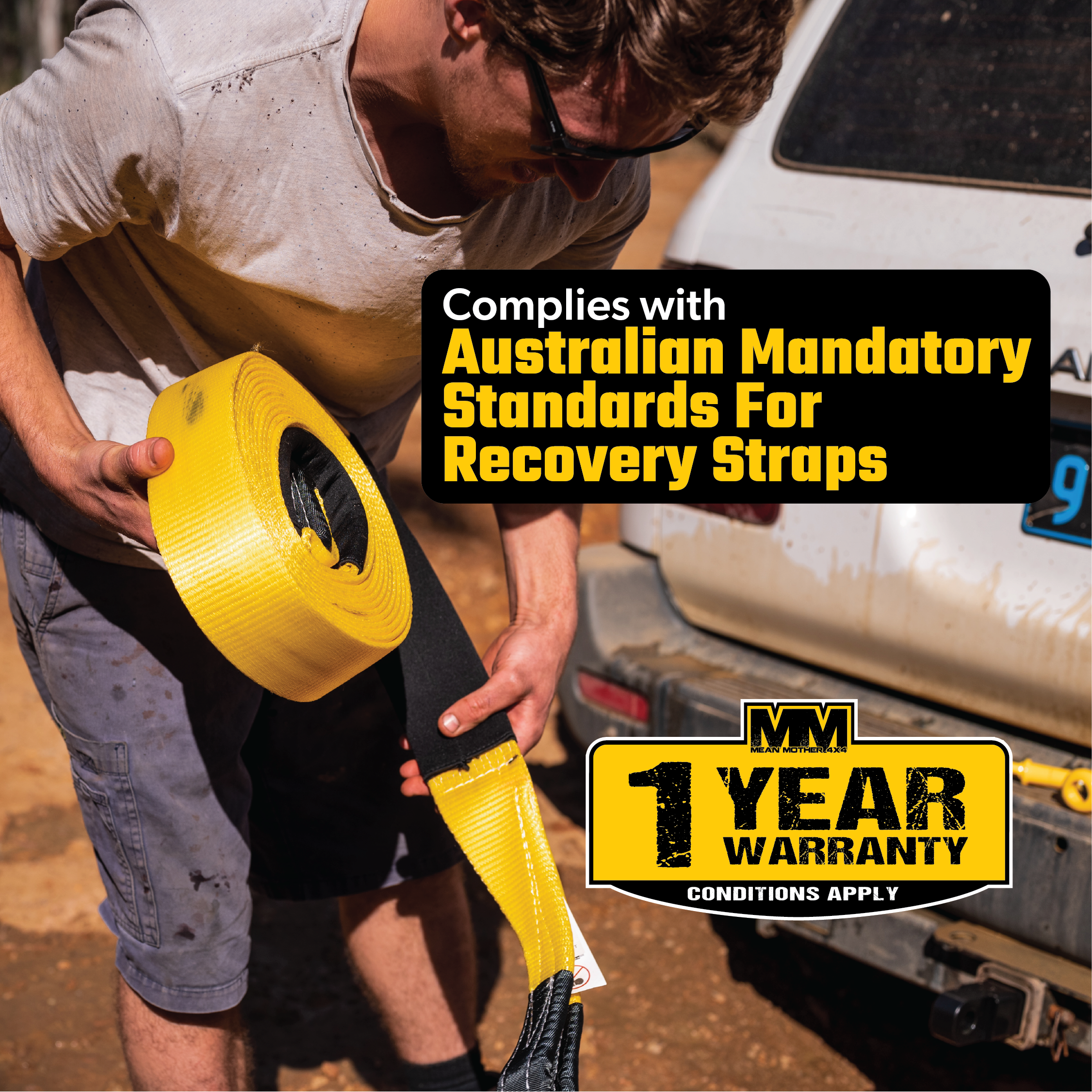 A person holding a Snatch Strap 8,000kg by Mean Mother near a white vehicle. Text overlay reads: "Complies with Australian Mandatory Standards for Recovery Straps," featuring reinforced eyelets and high tenacity nylon webbing, alongside "1 Year Warranty, Conditions Apply.