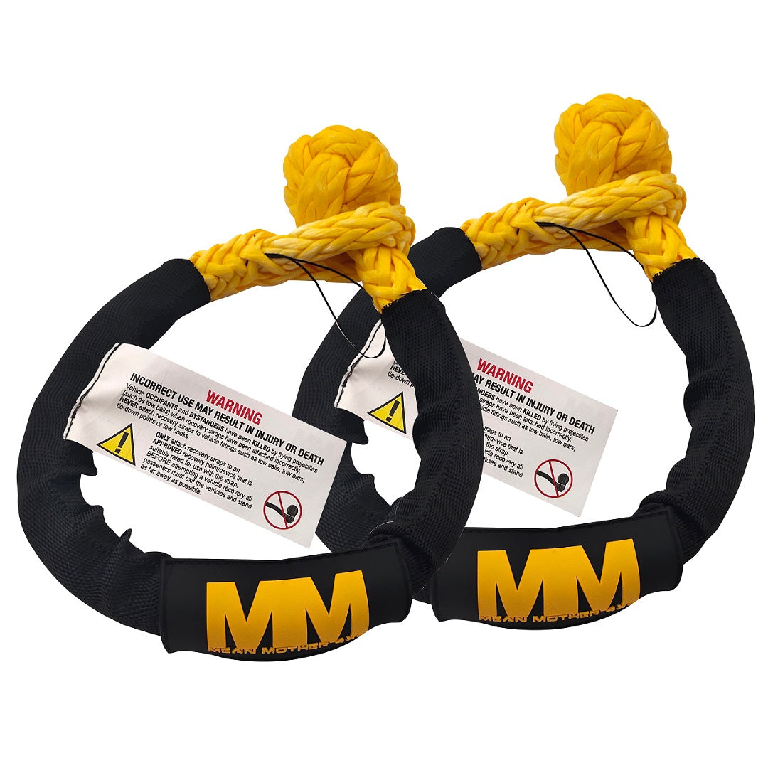 Two Mean Mother 4x4 Soft Shackle 14,700kg Twin Packs, featuring an eye-catching yellow and black design with looped ends and warning tags for safety, seamlessly fit into a typical 4x4 recovery kit. These shackles are crafted from UHMPE synthetic material and prominently display the "MM" logo along with caution labels.