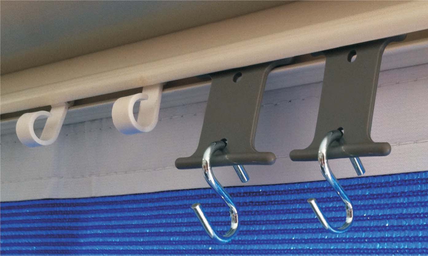 Close-up of the Caravan/RV Awning S-Hook Rail Hangers from Explore, effortlessly attached to an awning track. The scene shows two gray brackets with metal hooks and soft plastic hangers from a 6-pack set, smoothly gliding along the rail system. In the background, blue fabric with horizontal stripes adds a touch of texture and interest.