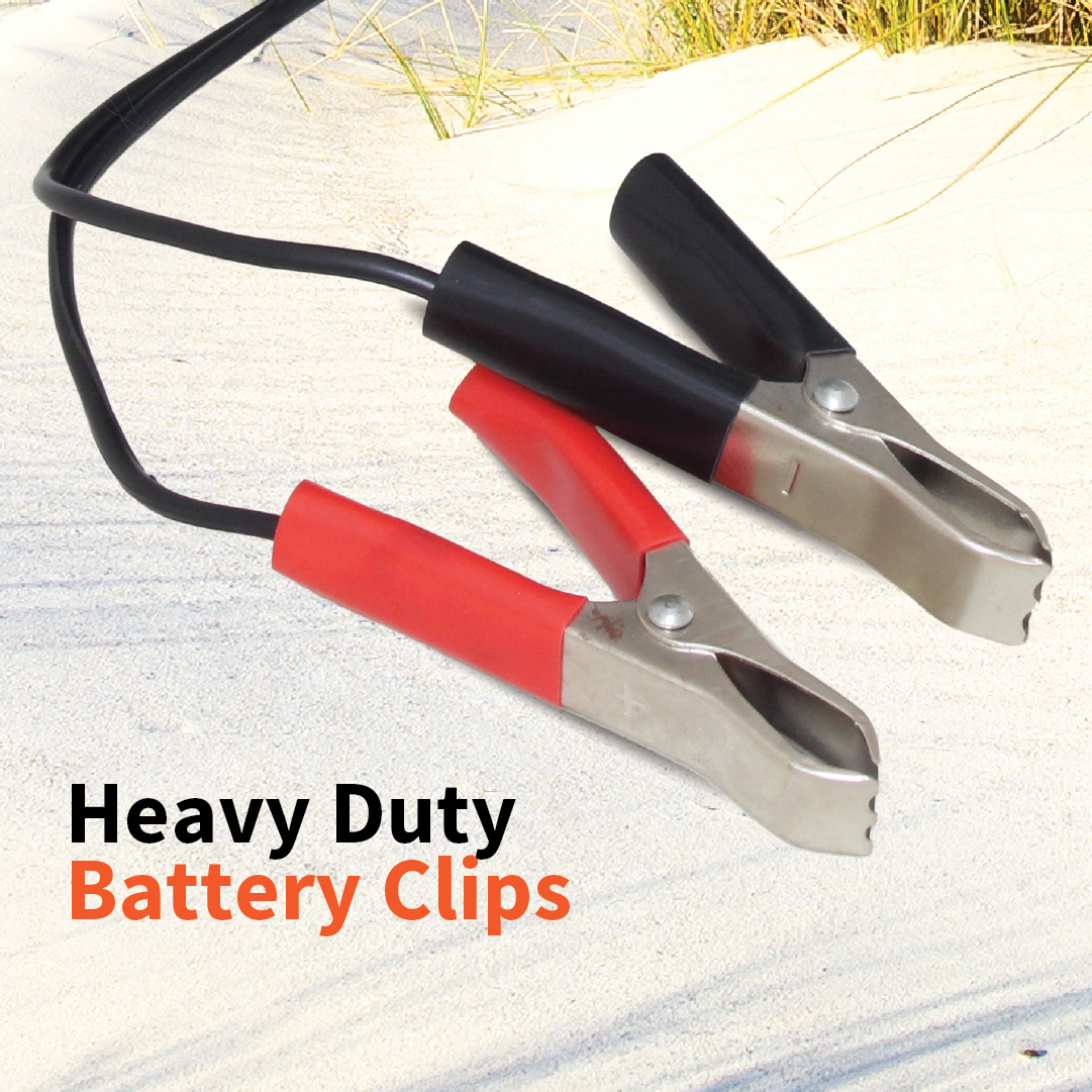 Close-up of two heavy-duty battery clips resting on a sandy surface, one vibrant red and the other sleek black, each connected to sturdy cables designed for powerful air delivery. "Dr Air 12V Air Compressor 45 Lpm - Heavy Duty Battery Clips" is elegantly displayed in the bottom left corner.