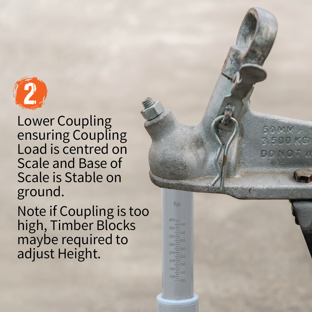 A close-up of a coupling mechanism attached to a trailer hitch, with an Explore Tow Ball Weight Scale underneath it. Instructions are provided in the image: "2. Lower coupling ensuring the load is centered on the scale and the base is stable on the ground. If the coupling is too high, timber blocks may be required for caravan weight safety.