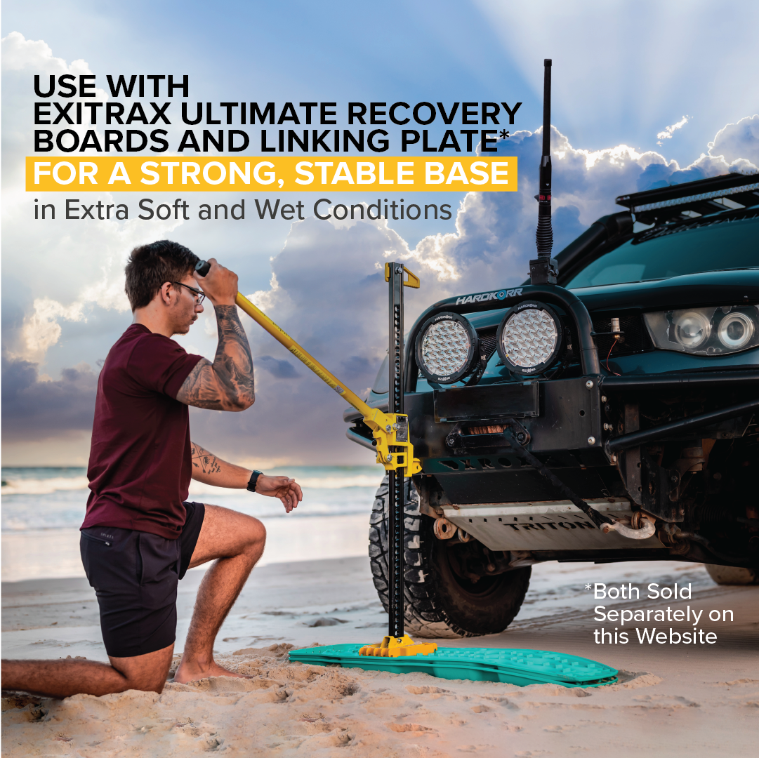 A man kneels on a sandy beach, using the Mean Mother High Lift Jack 48" as the lifting mechanism to elevate a green recovery board under an off-road vehicle. Text overlays promote Exitrax recovery boards and linking plate, essential recovery accessories for stability in soft conditions.