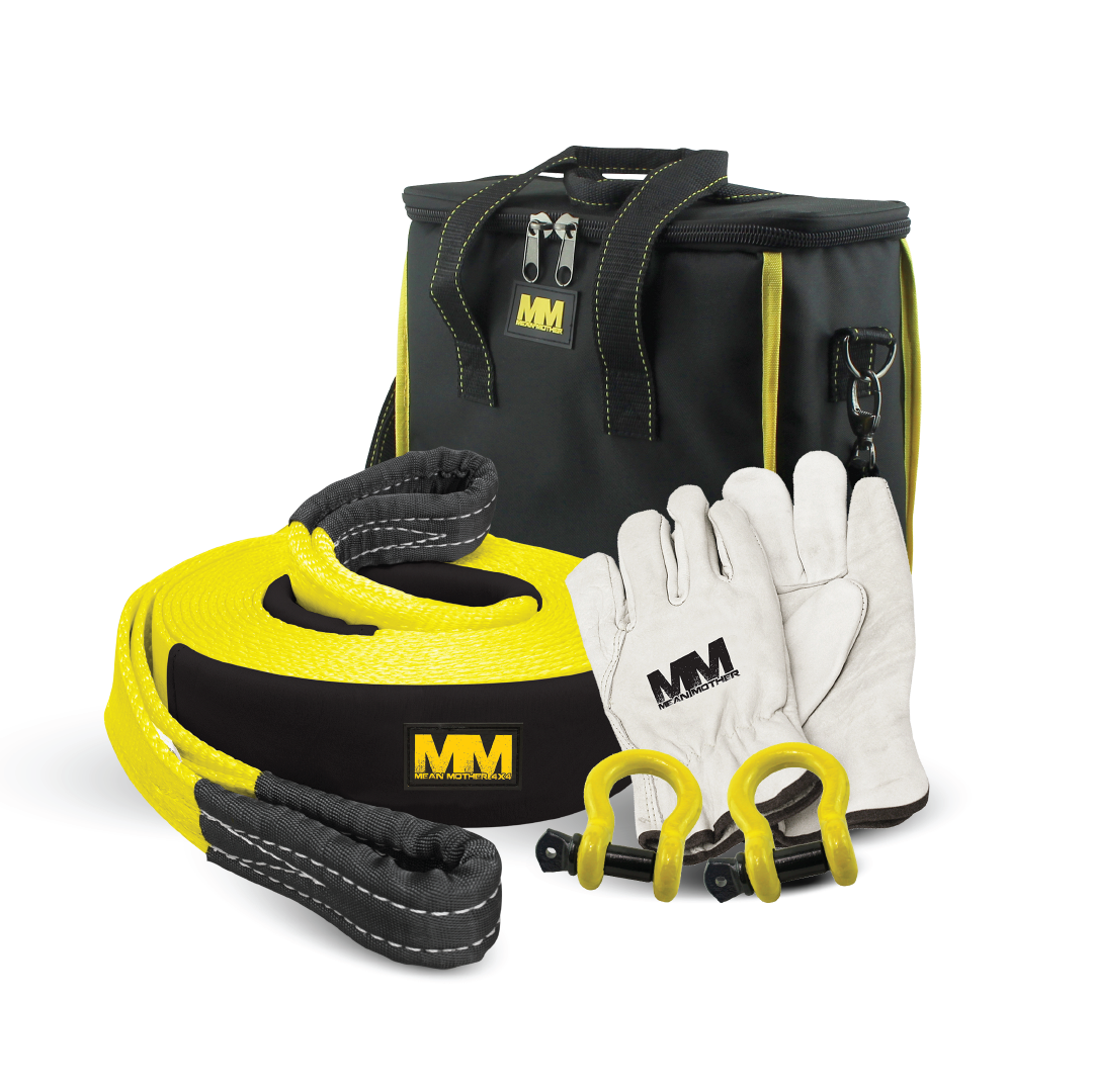 The Mean Mother 5pc Recovery Kit 8,000kg includes a black and yellow snatch strap, two metal shackles, a pair of white gloves, and a black carrying bag with yellow accents.