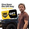 A man with long hair stands beside an off-road vehicle, wearing a brown shirt. The image includes the text, "Give them the gift they really want." It features a Mean Mother 4x4 Gift Card displaying the "MM Tough as Nails" logo, ideal for discovering 4x4 accessories.